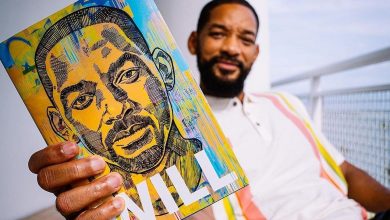 Will Smith holding his memoir, Will, towards the camera.